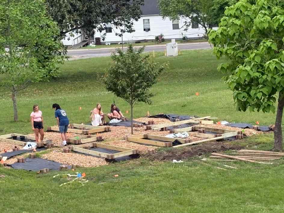 Students working in a school garden, setting up raised beds