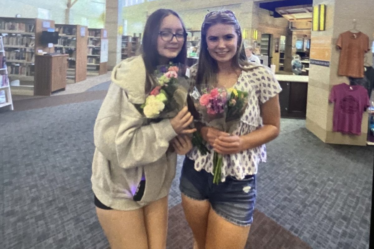 Stella and her partner delivering flower bouquets and handmade cards around their community